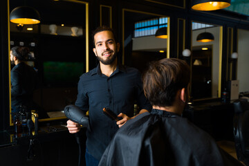 Portrait of a handsome male hairstylist at the salon