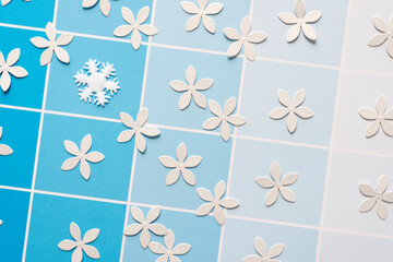 fabric snowflake and floral confetti scattered on blue scrapbook paper with squares