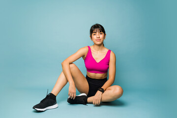 Sporty fitness coach posing against a blue background