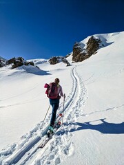 A woman on a ski tour towards Erdisgulmen in the Flumserberg. Ski climbing in beautiful Switzerland. High quality photo