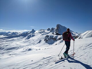 Fototapeta na wymiar A woman on a ski tour towards Erdisgulmen in the Flumserberg. Ski climbing in beautiful Switzerland. High quality photo