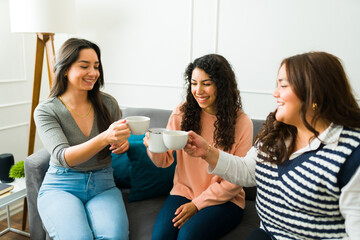 Smiling cheerful best friends drinking coffee or tea