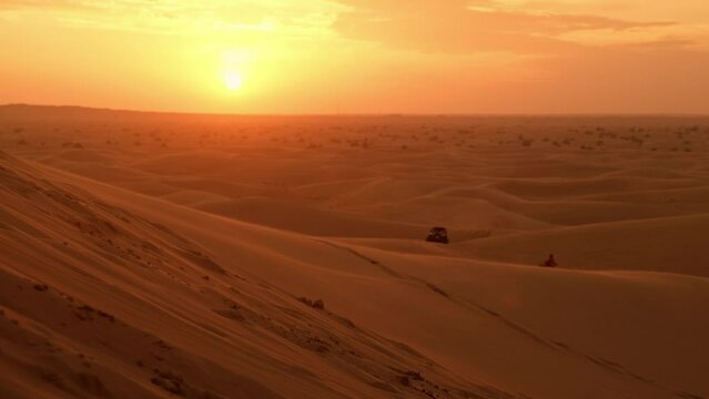 4x4 vehicles on desert dunes in the evening sun