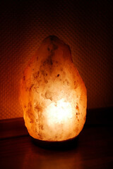 Salt lamp burning in a dark room, antibacterial effect, wellness, immune strengthening. Lamp hood from pink
 Himalayan salt
