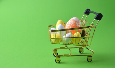 Easter eggs in a shopping basket on a green background. Easter.