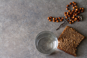 Rosary, water and bread. Lent Season, Holy Week, Good Friday. Religious concept