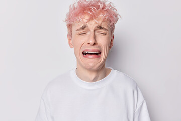 Gloomy upset man with pink hair cries from despair complains about bad life whines desperately...