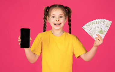 Happy Little Girl Showing Blank Smartphone And Euro Cash Money At Camera