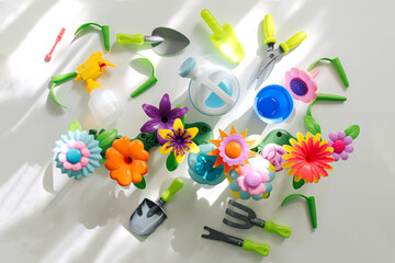Colorful flower garden toys and planting tools on white table. Garden themed toys for kids. Pretend play, Montessori activity