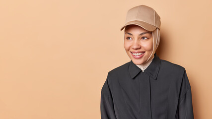 Portrait of emotive good-looking caucasian woman laughing while looking aside and standing against white background. Positive housewife on shopping with kids. Fashionable girl talks with friends