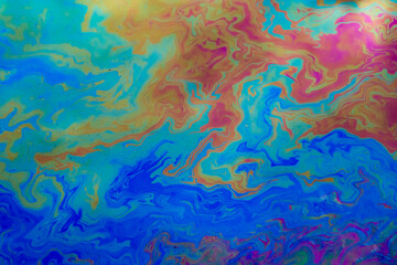 Fototapeta na wymiar colored stains of gasoline oil on the water, iridescence