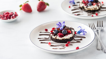 A sweet mixed berry cheesecake tart drizzled with chocolate.