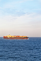 Large cargo ship sailing in open sea on sunny day - 580366564