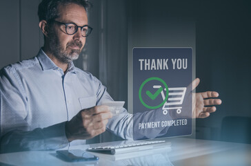 Man behind computer keyboard, purchase and pay online. Credit card in hand. Secure payment completed