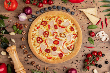 Pizza with Chicken, Bell Pepper and Cheese on Rustic Table.
Baked round pizza topped with chicken slices, red bell pepper and melted cheese, surrounded by fresh Italian ingredients on wood.