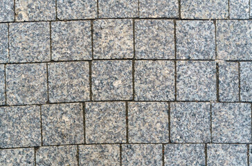 Abstract background of gray paving slabs from small stone, close-up.