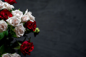 bouquet of red and white roses on a stone background with copy space for your text 