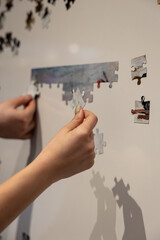 Shuffled magnetic puzzle pieces on a magnet white board waiting to be put together.