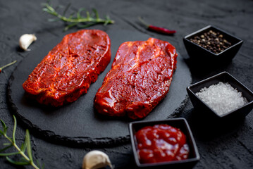 marinated raw pork steaks on stone background 