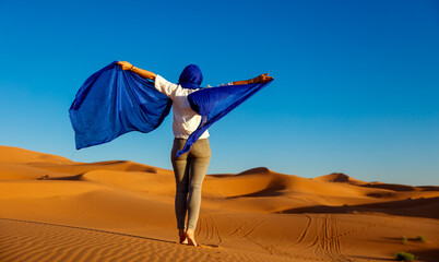 Beautiful caucasian woman posing in blue turban in the sahara desert - obrazy, fototapety, plakaty