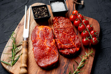 marinated raw pork steaks on stone background