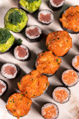 Assorted Sushi Platter with Salmon, Tuna, and Avocado Rolls on Turquoise Background. Vibrant sushi platter featuring a variety of maki and nigiri rolls with salmon, tuna, avocado, and cream cheese. Se