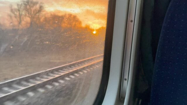 View from the window of a high-speed passenger train on flights and sunset, autumn season. High-speed comfortable trains. Travel by train