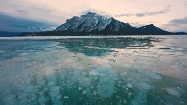 Abraham Lake with natural bubbles frost in the morning on winter at Banff national park