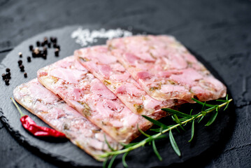 sliced ​​sausage with ham with cucumbers and onions on a stone background