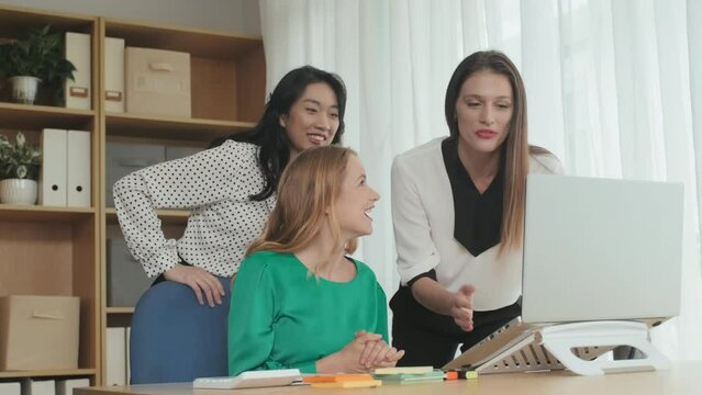 Blond businesswoman showing her colleagues good news on laptop screen and all of them starting clap hands and greet someone during communication in video chat