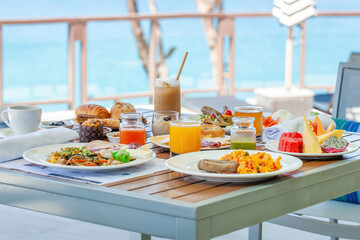 Breakfast in tropical hotel with sea view. Buffet food in restaurant in modern resort. Concept of travel and summer vacation.