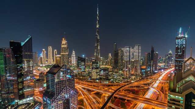 Day to night zoom in timelapse view of iconic skyscrapers and traffic on major interchange in Downtown Dubai, United Arab Emirates (UAE), business and finance concept, modern cities and skylines. 