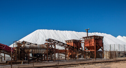 Fototapeta na wymiar Picture of salt factory equipment and salt piles.