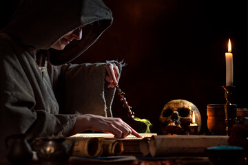 Young witch with magic wand and magic book