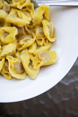 Homemade Italian food ravioli stuffed with spicy meat, close-up, sliced on a plate.