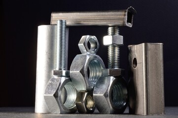 composition of nuts bolts and scraps of metal laid out on a dark background.