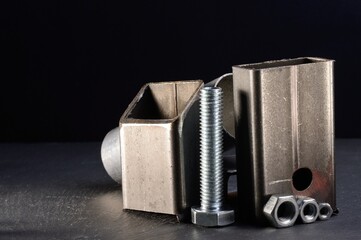 composition of nuts bolts and scraps of metal laid out on a dark background.