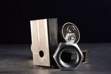 composition of nuts bolts and scraps of metal laid out on a dark background.
