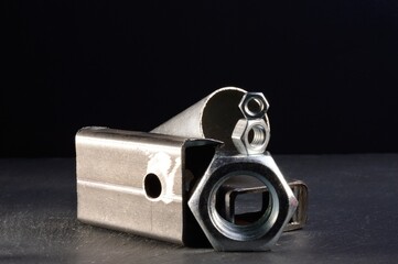 composition of nuts bolts and scraps of metal laid out on a dark background.
