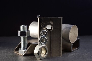 composition of nuts bolts and scraps of metal laid out on a dark background.