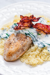 poultry breast with spinach creamy sauce and bacon served with couscous
