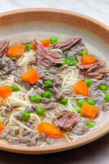 beef broth with green peas, carrot and small meatballs
