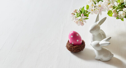 Holiday composition with spring flowers and easter eggs, white bunny on a light background. Happy easter concept with copy space