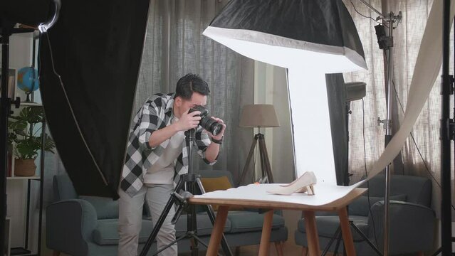 Asian Male Photographer Taking Photos Of Women'S Shoes In Home Studio 
