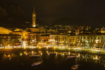 Fototapeta na wymiar Nighttime aerial cityscape of Lecco town. Picturesque waterfront of Lecco town located between famous Lake Como and scenic Bergamo Alps mountains.