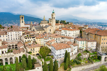 Obraz premium Scenic aerial view of Bergamo city. Flying over Citta Alta, town's upper district, known by cobblestone streets and encircled by Venetian walls. Bergamo, Lombardy, Italy.