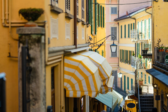 Narrow street full of shops and restaurants in Bellagio, one of the most picturesque towns on the shore of Lake Como. Charming location with typical Italian atmosphere. Bellagio, Italy.