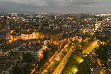 Scenic aerial view of Bergamo city northeast of Milan, on cloudy evening. Flying over Citta Alta, town's upper district encircled by Venetian walls. Bergamo, Italy.