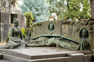 Impressive sculptures on the tombs and monuments of Cimitero Monumentale di Milano or Monumental Cemetery of Milan. Milan, Italy.