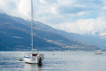 Small yacht docked in the marina of Varenna, one of the most picturesque towns on the shore of Lake Como. Varenna, Italy.